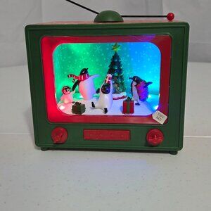 Retro TV musical Christmas decoration featuring an animated penguin scene & tree